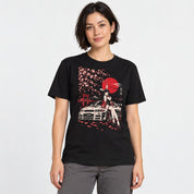 Female model wearing the Sakura Night Car T-Shirt in Black, showing the cherry blossom, red moon and car artwork