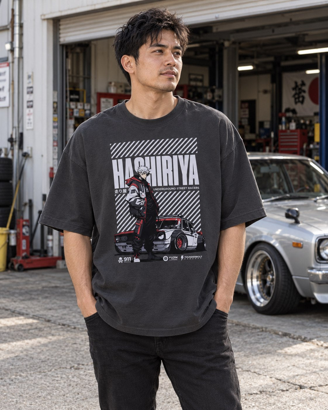 Hashiriya oversized faded black car T-shirt worn outside a garage beside a classic car